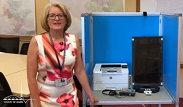 Image of the registrar standing next to a ballot marking device